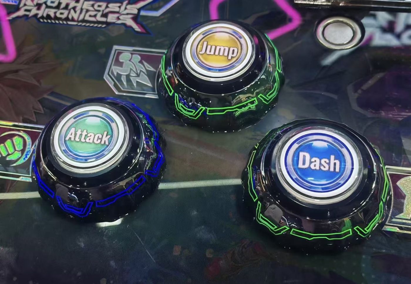 Three illuminated iridescent dome buttons marked Attack, Jump and Dash on an arcade control panel